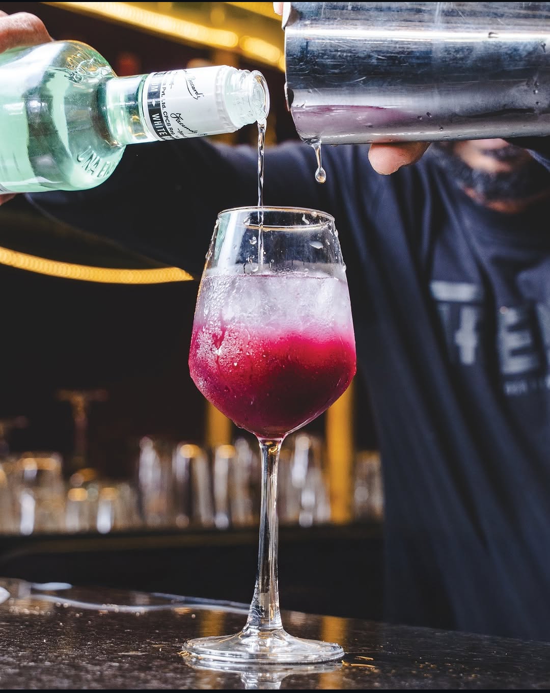 Bartender pouring a signature berry cocktail