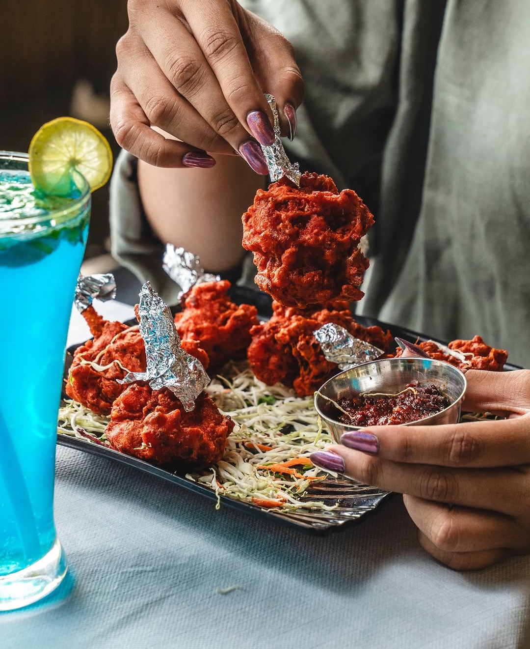 Foil-wrapped chicken lollipops with blue lagoon